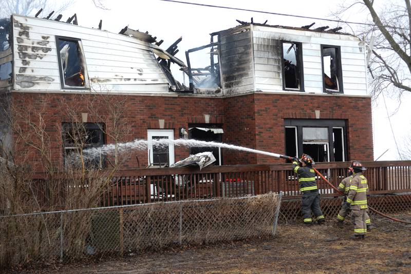 Firefighters spray water on flames at a house fire at 8423 East Illinois route 38 on the afternoon of Wednesday, March 5, 2025.