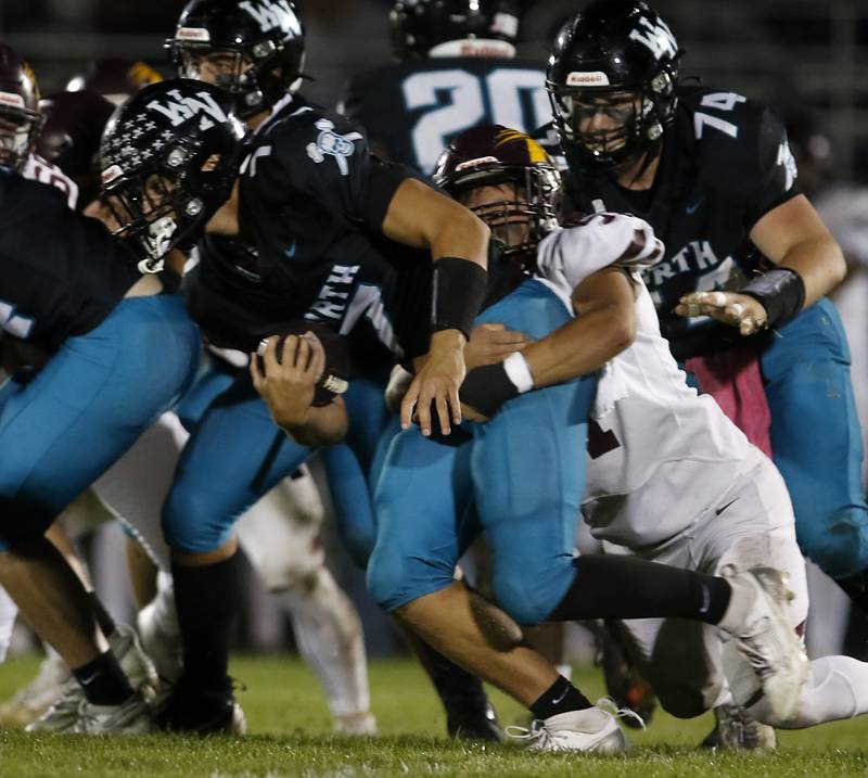 Richmond-Burton's Dylan Falasca (right) tackles Woodstock North's Parker Halihan during a Kishwaukee River Conference football game on Friday, Oct. 10, 2025, at Woodstock North High School.