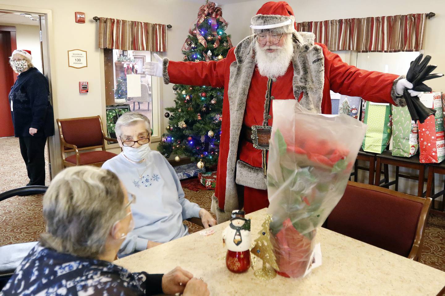 Santa Claus visits with residents during an adopt-a-grandparent gift event at Gable Point Senior Housing on Wednesday, Dec. 22, 2021, in Crystal Lake.