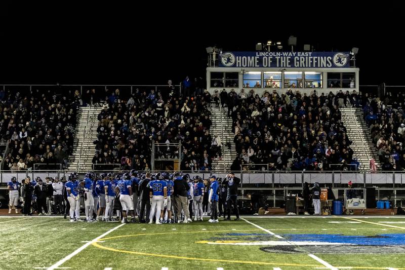 Lincoln-Way East’s varsity football team huddles up after the first quarter during a game against Sandburg at Lincoln-Way East on Oct. 23, 2025.
