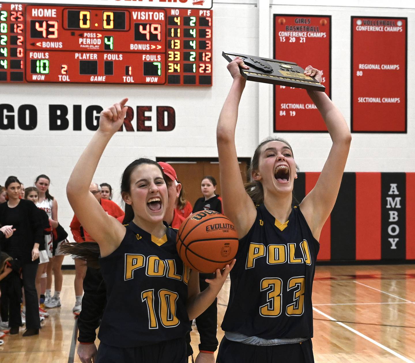 Polo's Annalise Stamm (10) holds the game ball while Lindee Poper (33) holds up the regional championship plaque Friday night in Amboy. The Marcos won their first regional title since 2008.