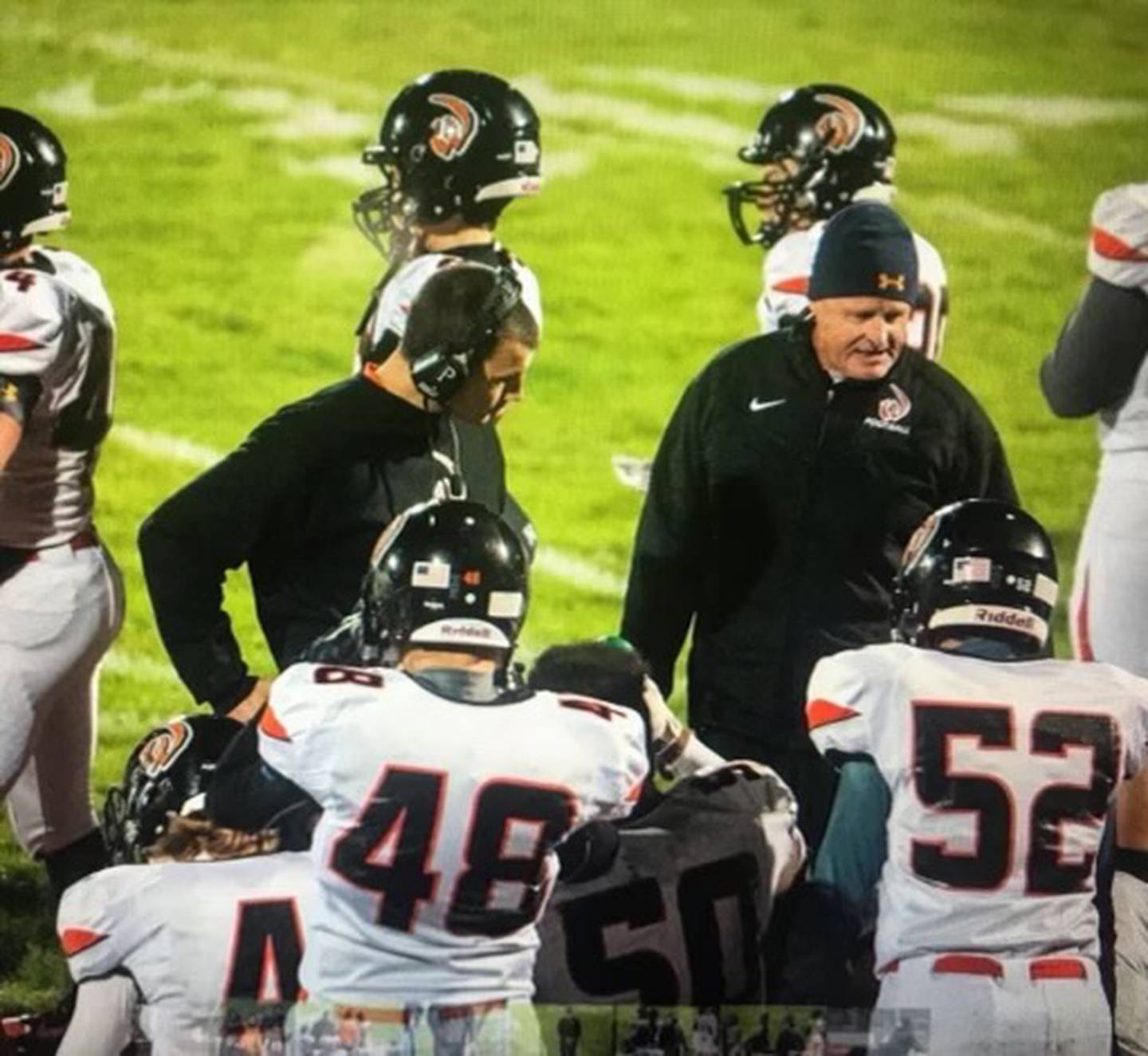 Larry Lokanc (right) talks to the players at Lincoln-Way West during a game.