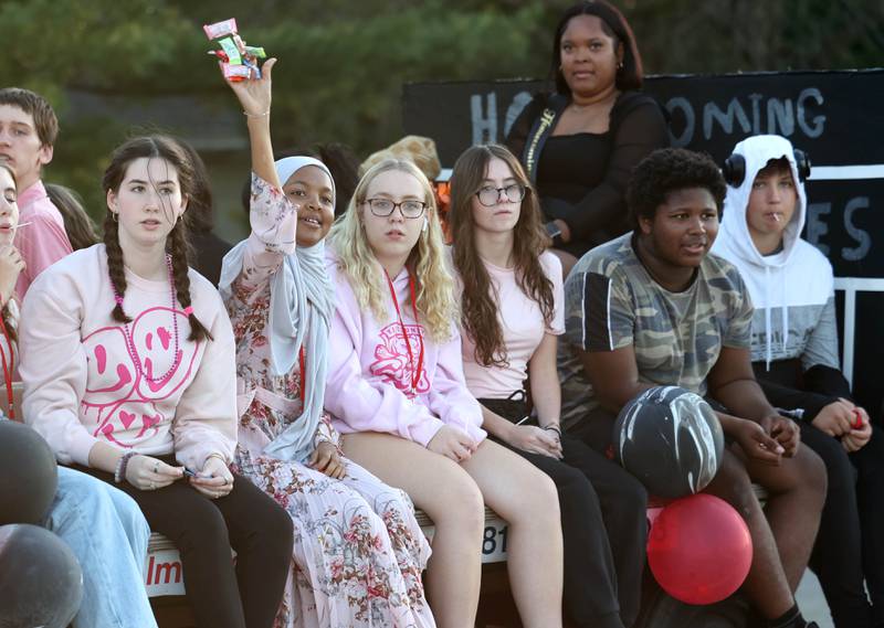 Riders on the DeKalb High School sophomore float throw candy to parade goers as the head West Dresser Road Wednesday, Oct. 2, 2024, during the DeKalb homecoming parade.