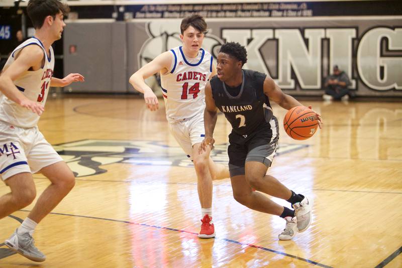 Kaneland's Jabe Haith is pressured by Marmion Academy's Henry Dalmann (32) and Evan Stumm (14) at the Class 3A Regional Final at Kaneland on Saturday, Feb.25, 2023.