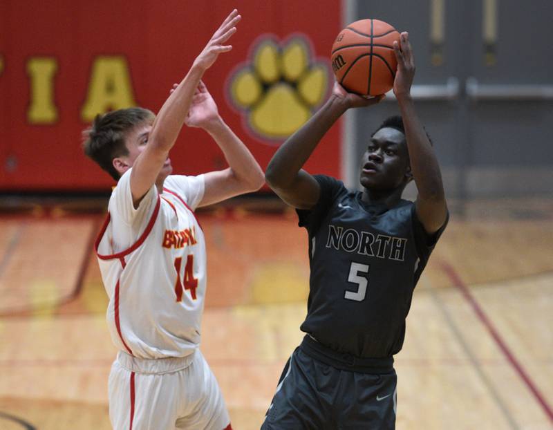 Glenbard North's Eddy Redento (5) takes a shot over Batavia's Jack Ambrose during Tuesday’s boys basketball game in Batavia.