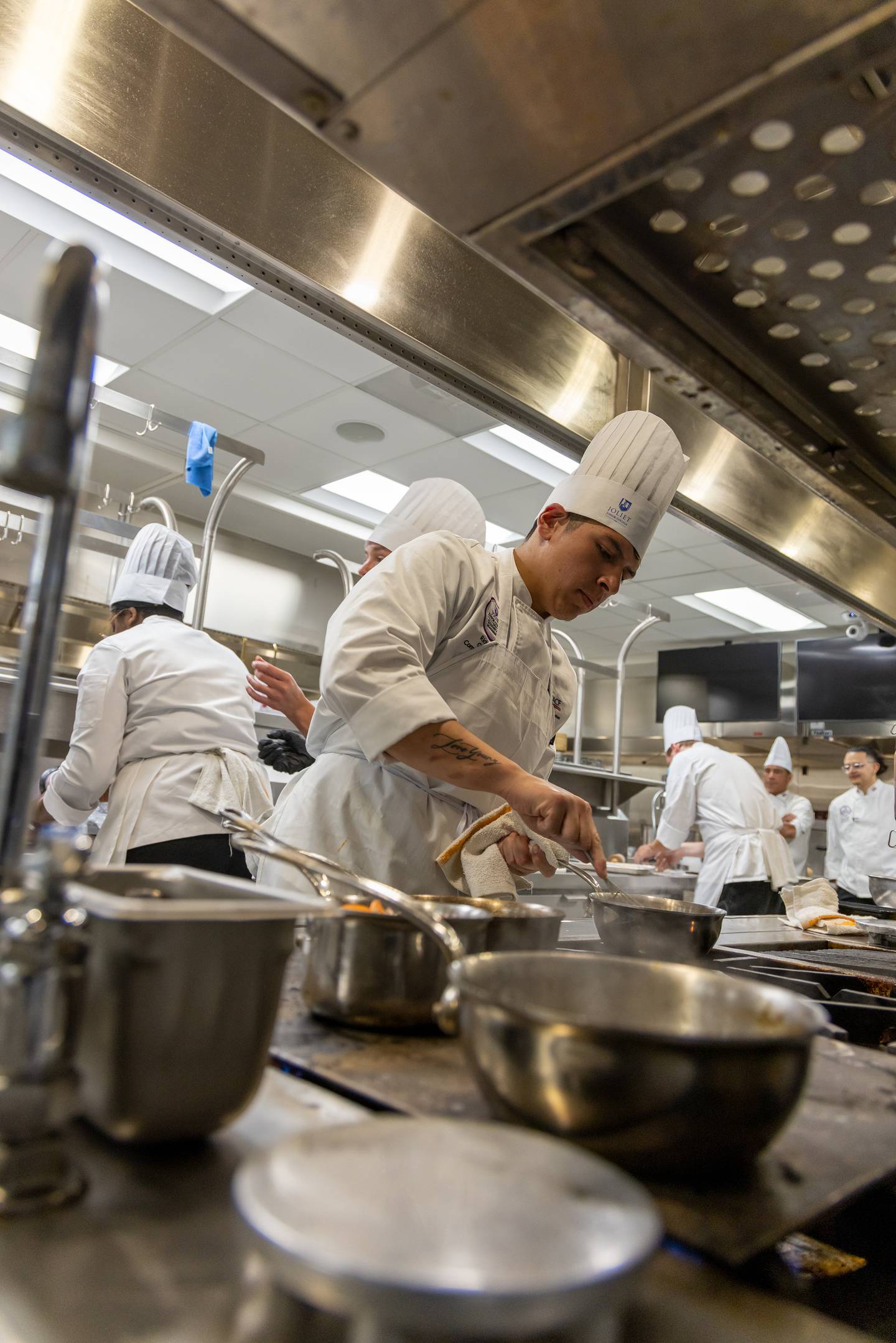 Joliet Junior College culinary arts program.  taken in 2023 of our then-student competition team during a practice. JJC PR said: I think they illustrate the action and dynamics of the training kitchens at City Center campus.