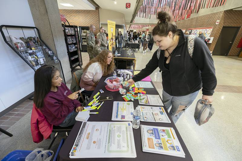 Lutheran Social Services of Illinois representatives Tina Berkely, left, and Shelley Hinton speak with Kelly Rockhold of Sterling about their programs from a booth at SaukFest.