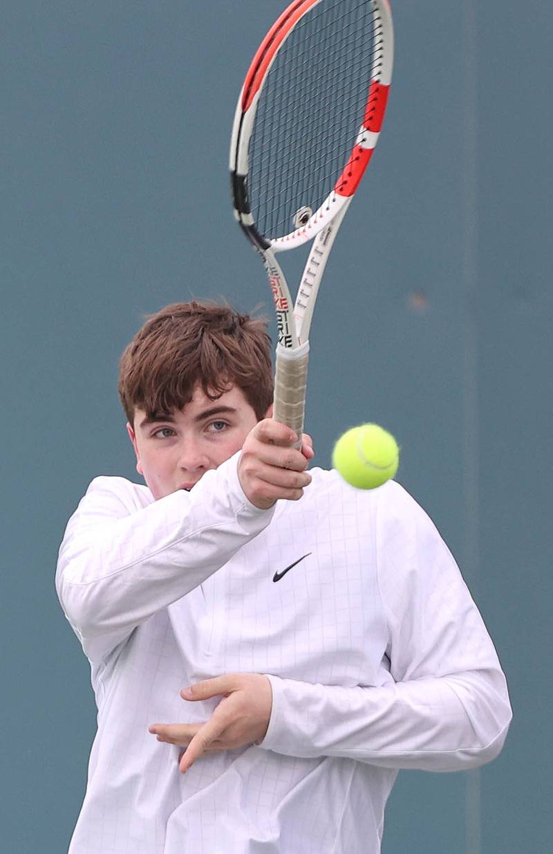 Dixon’s Owen Winter follows through on a forehand during his number one doubles match along with partner Derek Miller against Sycamore Thursday, March 30, 2023, at Sycamore High School.