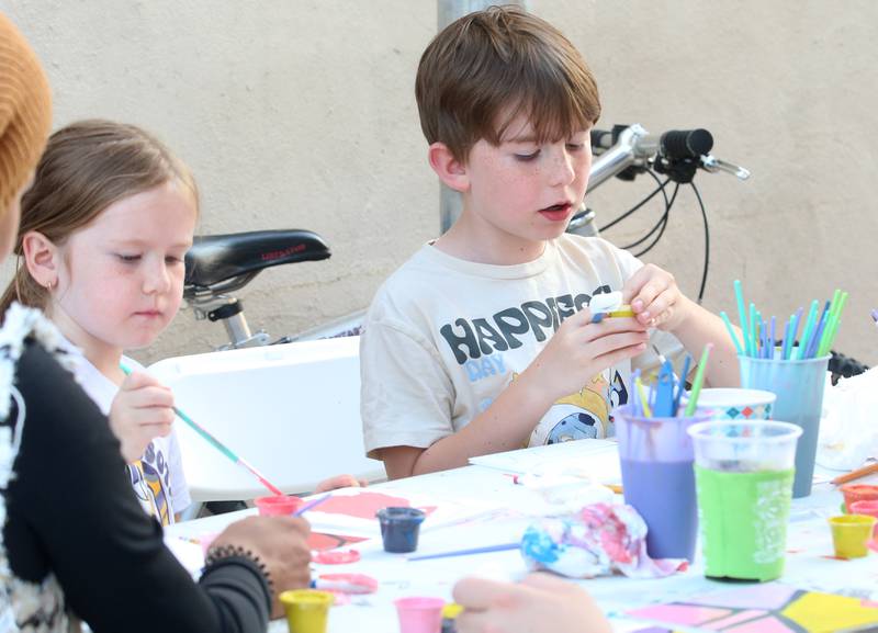 Evelyn Whitford and her brother Ben, paint a tile for the community mural project with the Princeton Public Arts Commission on Friday, June 20, 2025 downtown Princeton. The new mural will be displayed in the "Prairie Dreams" alleyway next to Fawcetts Pharmacy on South Main Street in Princeton.  “Prairie Dreams” is a living room grouping of mosaic-clad furniture (sofa, table and chairs) set under cloth sails and string lights along The Mary Uthoff Memorial Walkway.