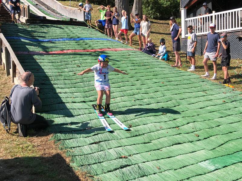 The first jumpers on Saturday, Oct. 4, 2025, at Norge Ski Club's annual Jumptoberfest tournament. Athletes - including to children just entering the sport- jumped on all of the hills in 80-degree weather.