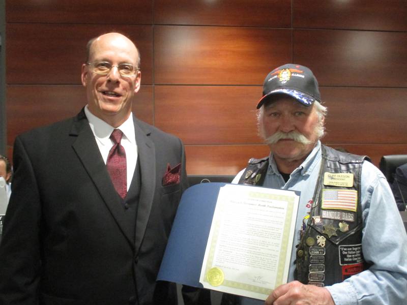 Cliff Oleson, right, displays a proclamation from Yorkville Mayor John Purcell on May 9, 2023 declaring May to be Motorcycle Awareness Month.