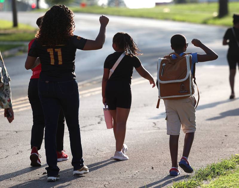 Marchers chant slogans as they head west on Hillcrest Drive Friday, July 18, 2025, during the DeKalb Peace Walk and Rally. The event, which featured a march, food vendors and music, was held to encourage the community to work together against gun violence.