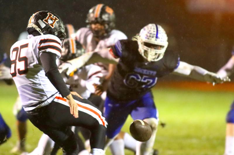 Burlington Central’s Aidan Nuno, right, closes in as Harlem’s Mason Burns punts in IHSA football Class 6A second-round playoff action at Central High School in Burlington on Saturday, November 8, 2025.