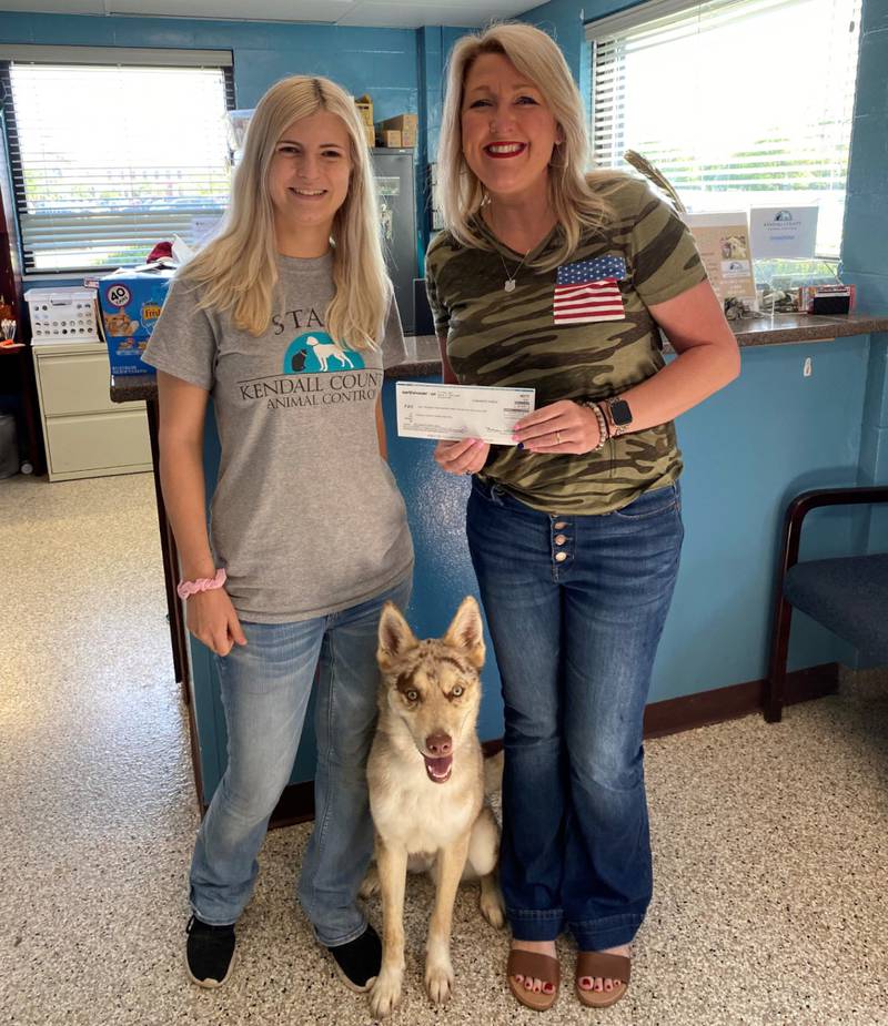 ECU Business Development Manager Heidi Baird, right, presents a check to Kendall County Animal Control Director Taylor Cosgrove.