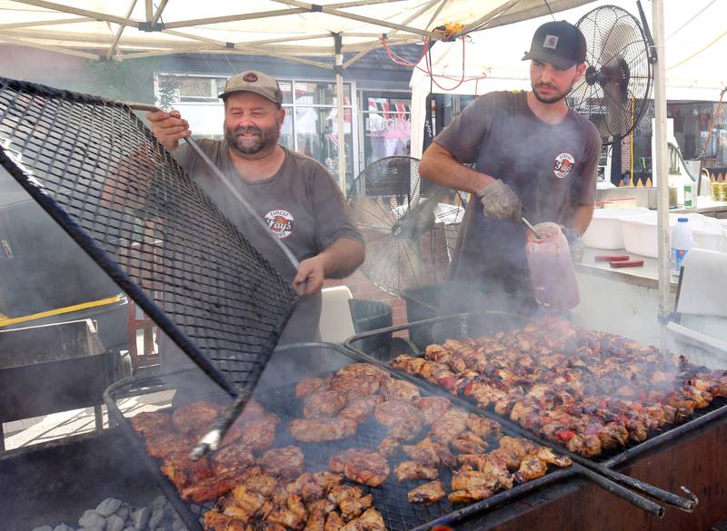 Nathan Fay (left) and Cayden Tewksbury, from Fay’s Finest Foods in Waterman, cook up some barbecue Friday, Aug. 22, 2025, during the first day of Corn Fest in downtown DeKalb.