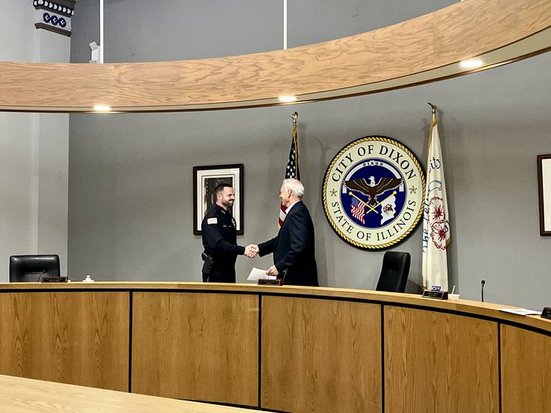 Dixon's new chief of police Ryan Bivins (left) shakes hands with Dixon Mayor Glen Hughes (right) after taking the oath of office at Monday's city council meeting, June 2, 2025.