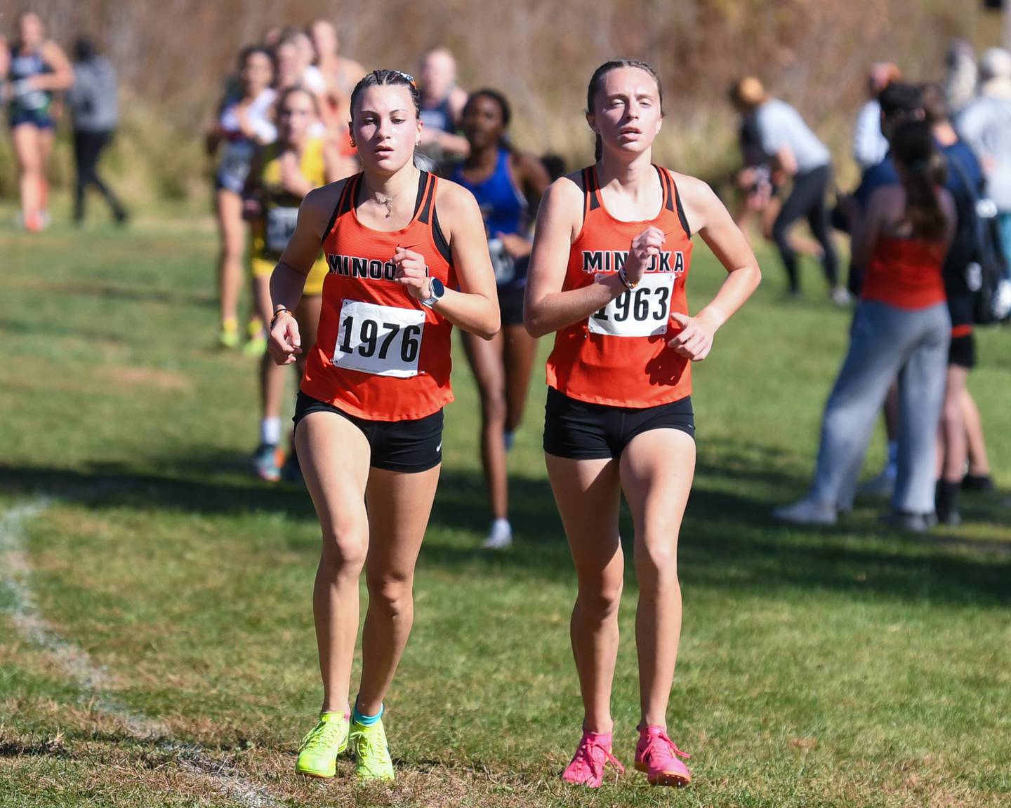 Minooka teammates Taya Gummerson, right and Natalie Nahs run during the conference meet on Friday Oct. 18, 2024, held at Channahon Community Park in Channahon.