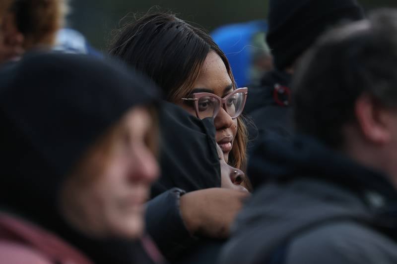 A woman holds a young girl during an emotional candlelight vigil for the victims of the March 5th shooting on Wednesday, March 8th, 2023 in Bolingbrook.