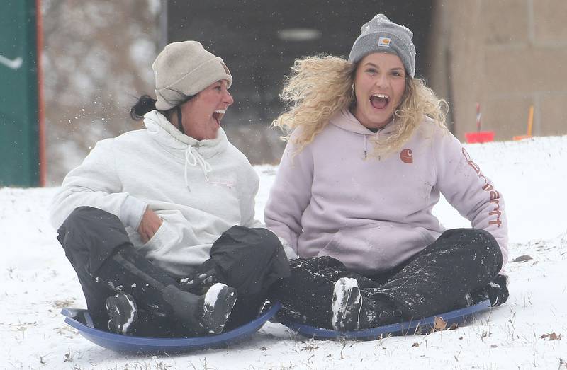 Madison Rahberg and Morgan Buckley both of Peru, sled down a large hill on Wednesday, Feb. 12, 2025 at McKinley Park in Peru.