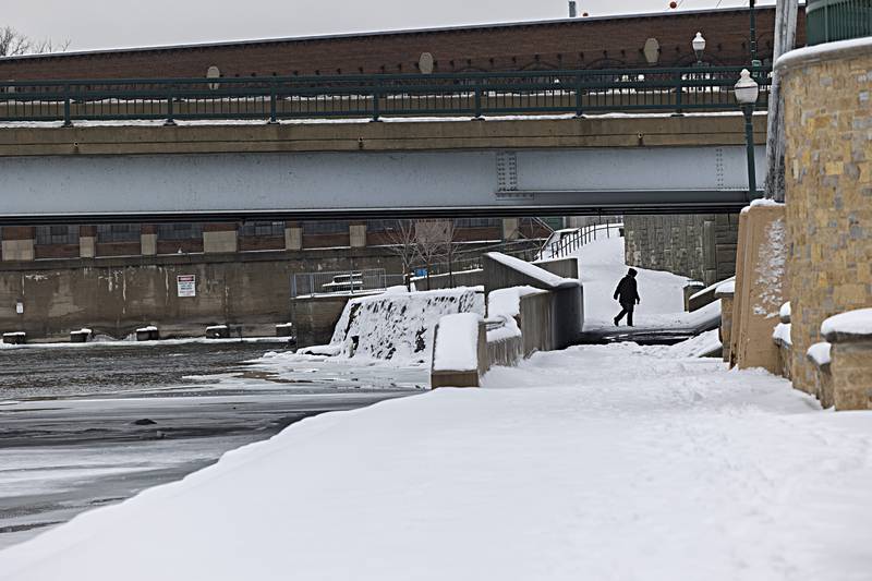 A pedestrian trudges through the snow along the Dixon riverfront Tuesday, Jan. 23, 2024. Temps rose above freezing making an afternoon stroll much more bearable.