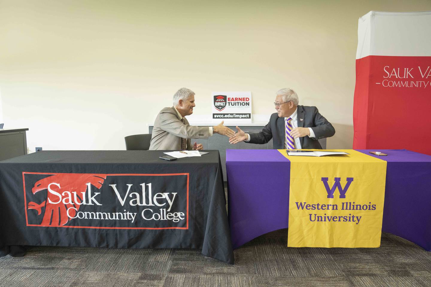 Sauk Valley Community College President Dave Hellmich signs an agreement with Western Illinois University President Guiyou Huang to help address the teacher shortage.