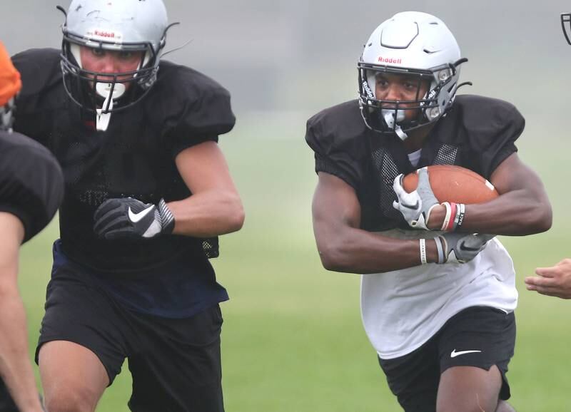Kaneland’s Aric Johnson follows his blockers on a running play during practice Wednesday, Aug. 9, 2023, at the school in Maple Park.