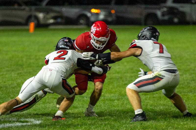 (center) Dylan Glynn (7) of Hall runs ball through Erie-Prophetstown defense (from left) Connor Keegan (2) and teammate Gaven Adams (7)  on Friday, Sept 5, 2025 at Richard Nesti Stadium in Spring Valley.