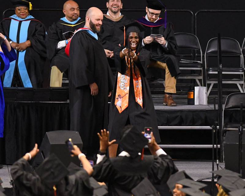 A DeKalb High School graduate shares their excitement with fellow graduates during the graduation ceremony as they walk across the stage on Saturday May 23, 2026, held at the Convocation Center in DeKalb.
