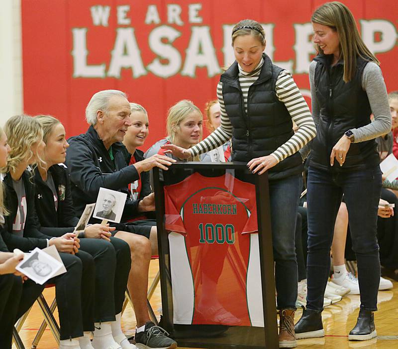 L-P head coach Mark Haberkorn receives a commemorative jersey with number 1000 from his daughters Malinda Nett and Mary Jo Glass during a special celebration after getting his 1000th career win against Ottawa on Tuesday, Oct. 18, 2022 at Sellett Gymnasium at L-P. Haberkorns family flew in this morning from Nev. and Wash. to celebrate his victory.