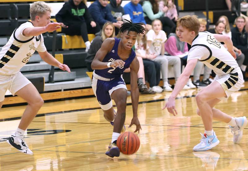Plano's AJ Johnson drives between two Sycamore defenders Tuesday, Jan. 3, 2023, during their game at Sycamore High School.