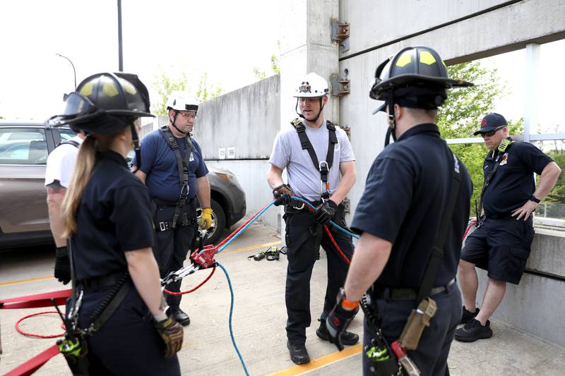 Geneva Fire Lt. Andrew Shad (center) briefs his colleagues during a rappelling training exercise at the Third Street Commuter Parking Deck on Tuesday, May 13, 2025 in Geneva.