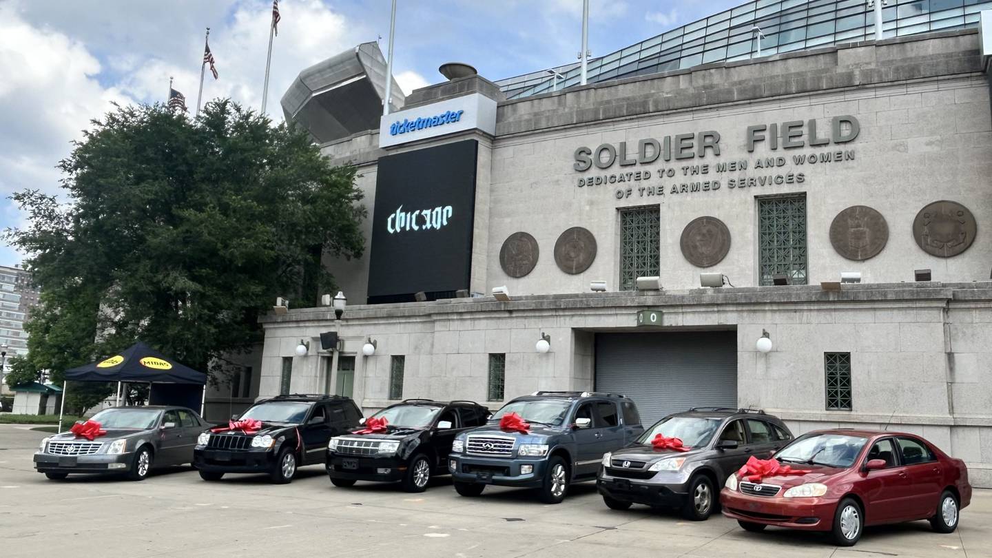 Six fully refurbished vehicles sit outside Soldier Field in Chicago, ready to be donated to veterans through Midas' Project Spark initiative on July 2, 2025.