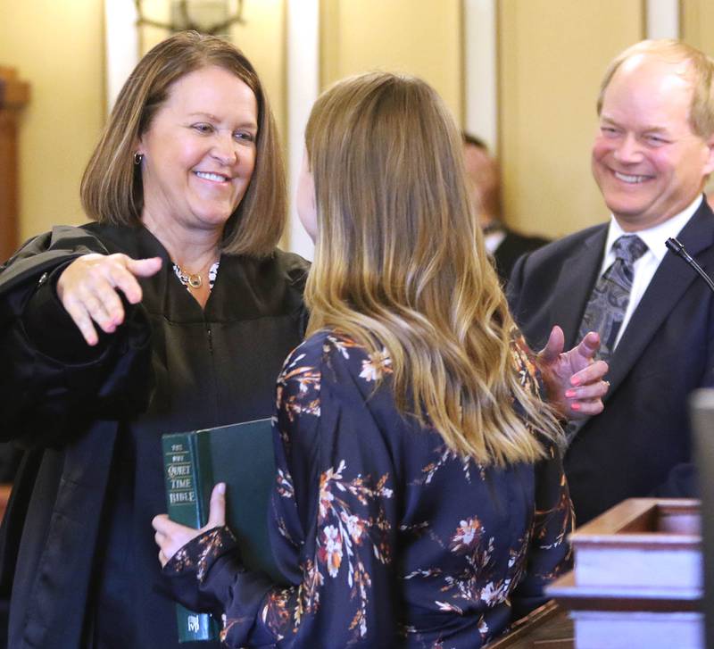 Judge Marcy Buick hugs her daughter Alison, 27, after being sworn in as a Judge in the 23rd Judicial Circuit Court as her husband Kevin looks on Friday in Courtroom 300 at the DeKalb County Courthouse. Buick is filling the void left when Judge Robbin Stuckert retired.