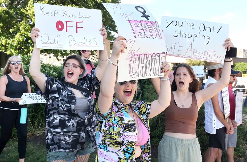 Oli Oczkowski, (left) 18, from Sycamore, Kendal Graham, 18, from Somonauk, and Alaina Bowman, (right) 16, from Sycamore, cheer as passing cars honk in support Friday, June 24, 2022, during a rally for abortion rights in front of the DeKalb County Courthouse in Sycamore. The group was protesting Friday's decision by the Supreme Court to overturn Roe v. Wade, ending constitutional protections for abortion.