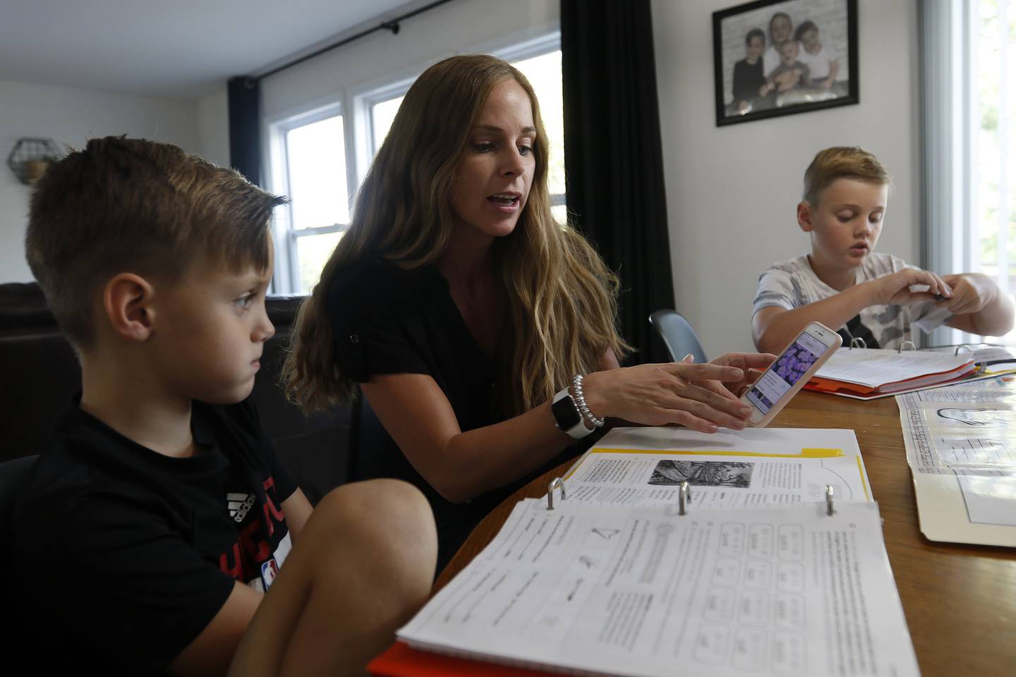 Jessica Clements helps her sons Gavin, 7, left, and Myles, 10, during a homeschool session with learning materials from The Good and The Beautiful at home on Tuesday, Aug. 17, 2021 in McHenry.  This is the family's first time trying home schooling.  Myles is in 5th grade, Gavin is in 2nd, and Dayne, 4, is in preschool.