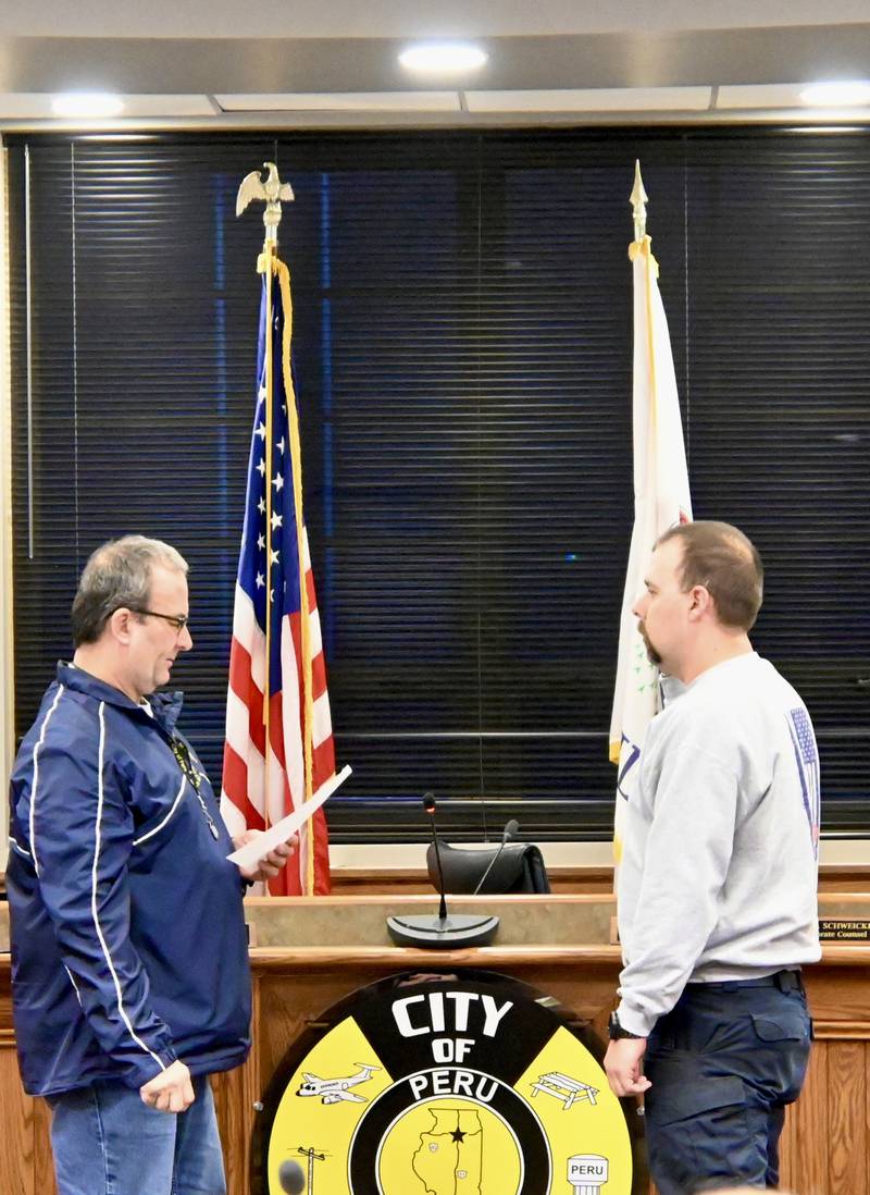 Peru Mayor Ken Kolowski swearing-in new firefighter Brandon Hamblen as a full-time fireman for the Peru Fire Department during Monday’s City Council meeting.