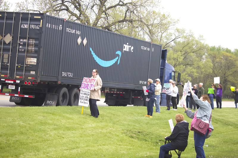 People hold up signs on Thursday, May 1, 2025, for a democracy rally in Joliet with signs critical of U.S. President Donald Trump. More than 20 people attended the rally held near the busy West Jefferson Street and the Joliet Regional Airport.