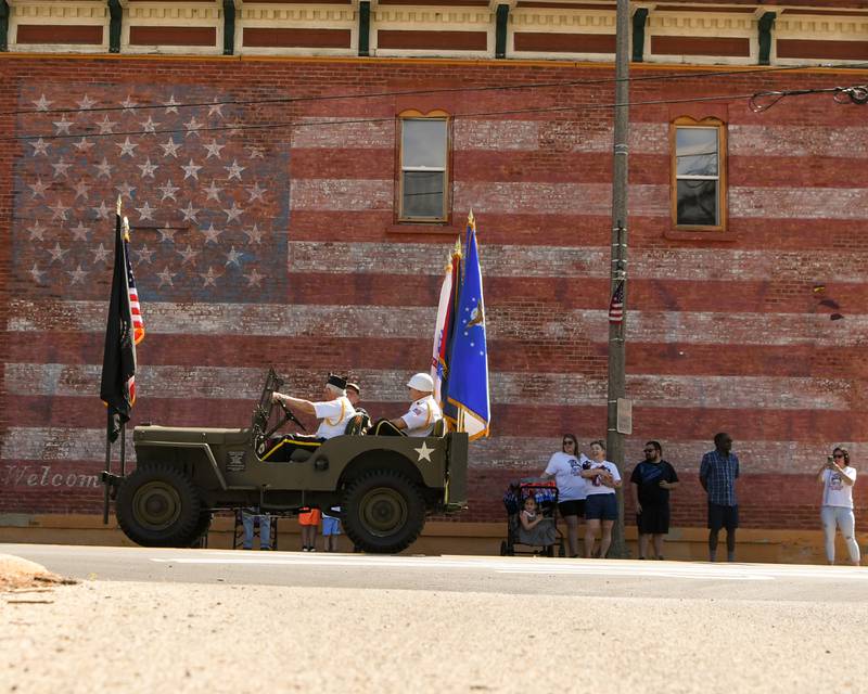 A military jeep with the United states and P.O.W. flag drives from Memorial Park in Plano to Little Rock Township Cemetery on Monday, May 29, 2023 for the Memorial Day remembrance ceremony.