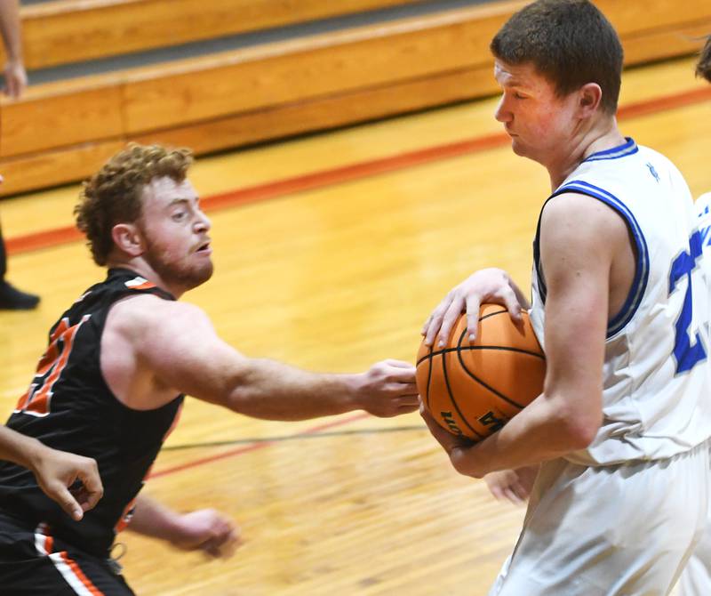 Sterling Newman's John Rowzee (23) protects the ball from Milledgeville's Spencer Nye on Saturday, Dec. 13, 2025 at the 64th Annual Forreston Holiday Basketball Tournament at Forreston High School.pro