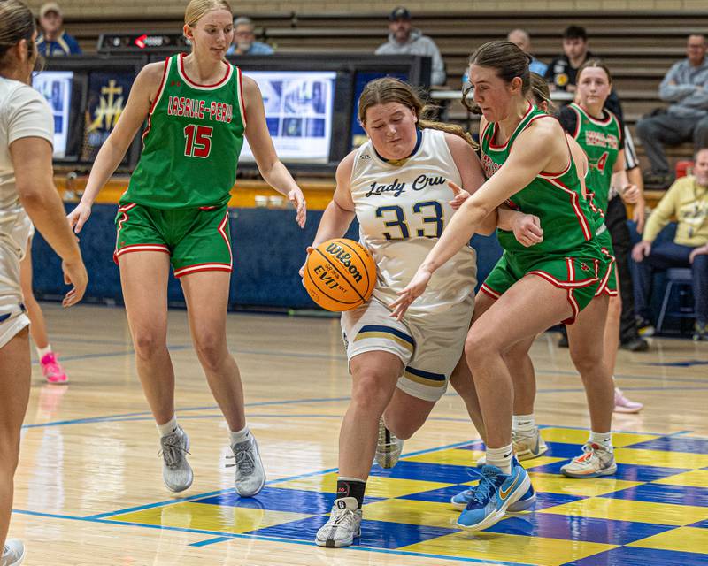 Madison Kozlowski (33) of Marquette drives ball in lane whilst Drew Depenbrock (14) of LaSalle-Peru reaches across body to steal ball on Saturday, January 3, 2026 at Marquette Academy in Ottawa.