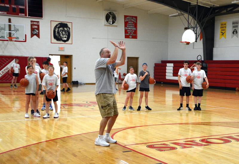 Pat Cinotte, coach for the Illinois Valley Warriors, demonstrates proper shooting form during Thursday's final session of the LaMoille High School basketball camp.