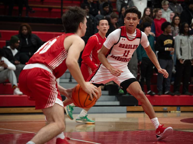 Bradley-Bourbonnais's Trey Lawrence, right, guards Naperville Central's Cooper Page, left, in a game on Monday, December 15, 2025.