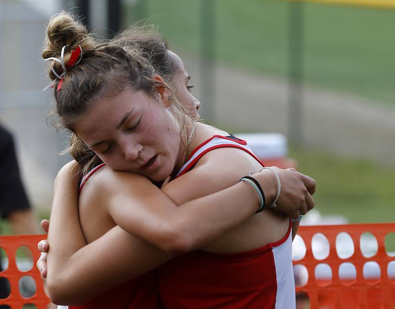 Huntley’s Haley Rahman is hugged by her teammate, Ava Allison, after they finished the girls race of the McHenry County Cross Country Meet Saturday, August 27, 2022, at Emricson Park in Woodstock.