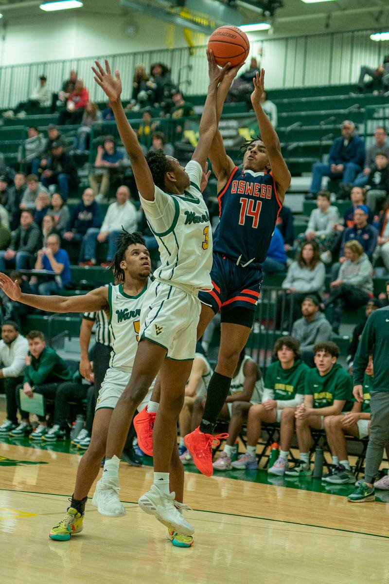 Waubonsie Valley's Tre Blissett (3) blocks a shot by Oswego’s Bryce Woods (14) during a Waubonsie Valley 4A regional semifinal basketball game at Waubonsie Valley High School in Aurora on Wednesday, Feb 22, 2023.