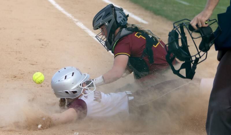 Marengo’s Lilly Kunzer slides home safely as Richmond-Burton’s Taylor Davison reaches for the ball in varsity softball at Marengo Tuesday.