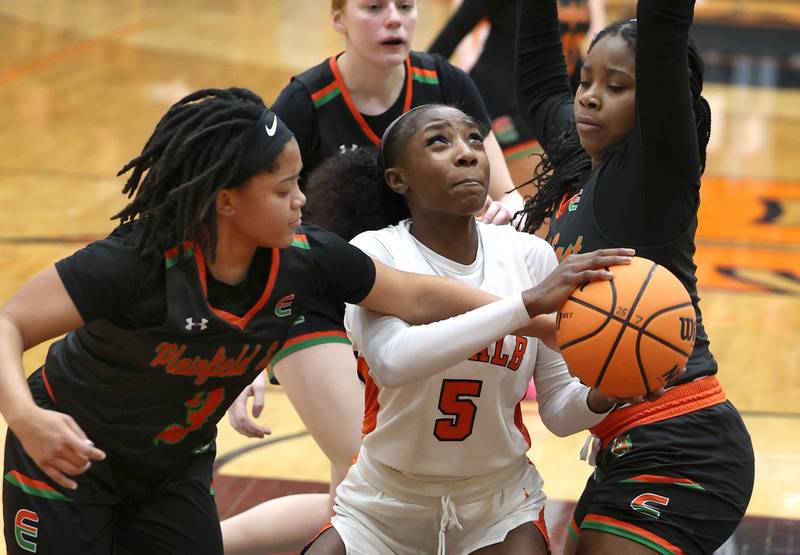 DeKalb's Me'She Eubanks tries to get a shot up between Plainfield East's Gianna Thompson (left) and Emwanmwosa Osazuwa Thursday, Feb. 12, 2026, during their game at DeKalb High School.