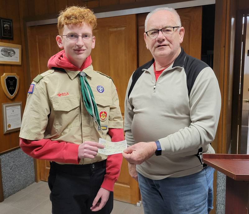 Marseilles Mayor Jim Hollenbeck (right) hands to Eagle Scout Dylan Trettenero a check from he and his wife, Sheila, a donation toward Trettenero's project of building a dog park in the city.