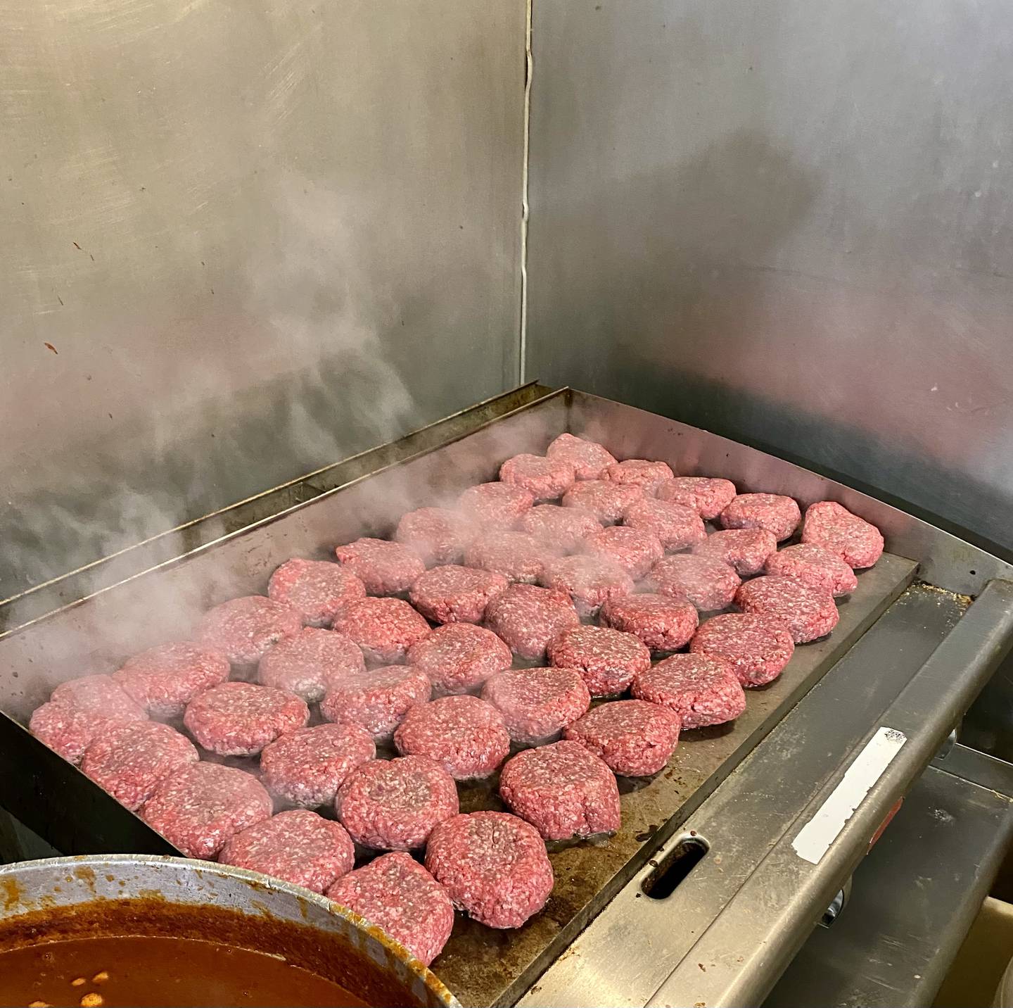 At Bristol Tap, burgers are slow grilled on a flat grill behind the bar, taking up to 25 minutes, with a recipe that has not changed in over 30 years.