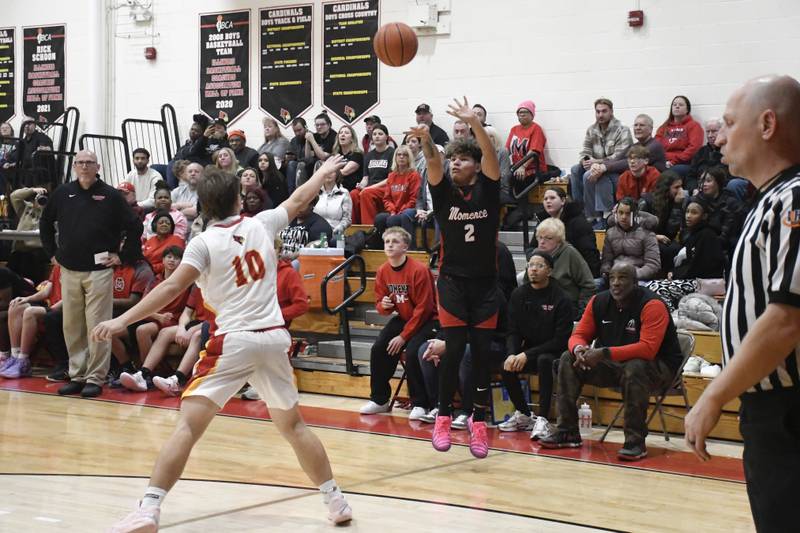 Momence's Erick Castillo shoots a three pointer over St. Anne's Grant Pomaranski during St. Anne's 61-46 victory over Momence on Tuesday December 9, 2025.