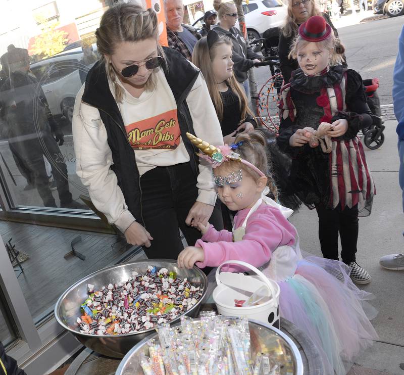 Costumed children line up Saturday, Oct. 29, 2022, to get a treat from Main Street Market during Streator's downtown trick-or-treating event.